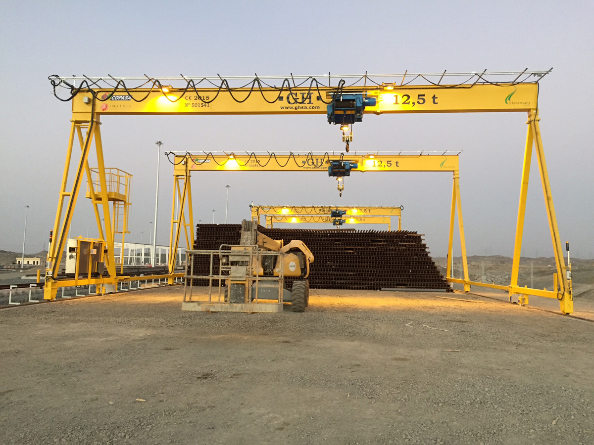 <br>La línea de ave en Arabia Saudi va desde la Meca a Madinat pasando por Jeddat, donde GH CRANES & COMPONENTS ha montado dos biporticos que alimentan la linea de soldadura de carriles (unen carriles de 50 metros mediante soldadura especial y forman uno de 300 metros). Una vez soldado lo almacenan mediante los 22 pórticos fijos que se han montado. También otros dos bipórticos para montaje de cambios de vía, cada bipórtico llevaba 250 metros de línea blindada.